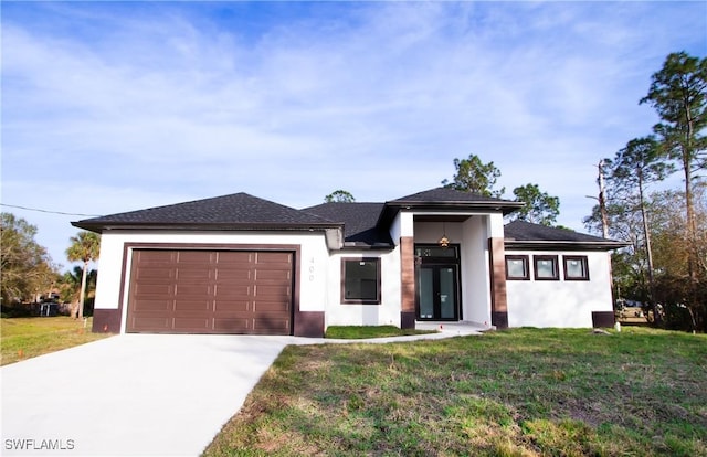 prairie-style home featuring a garage and a front yard