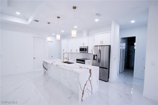 kitchen featuring sink, appliances with stainless steel finishes, white cabinetry, hanging light fixtures, and light stone countertops