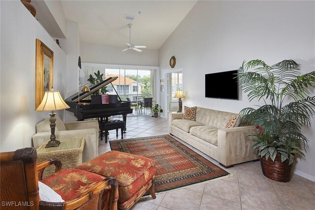 living area with tile patterned floors, ceiling fan, high vaulted ceiling, and baseboards