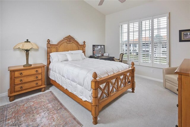 bedroom with lofted ceiling, light carpet, and ceiling fan