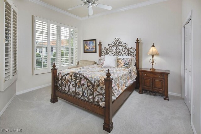 carpeted bedroom with baseboards, crown molding, a closet, and ceiling fan