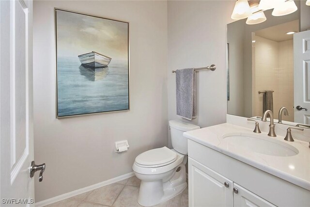 bathroom featuring toilet, tile patterned floors, baseboards, and vanity