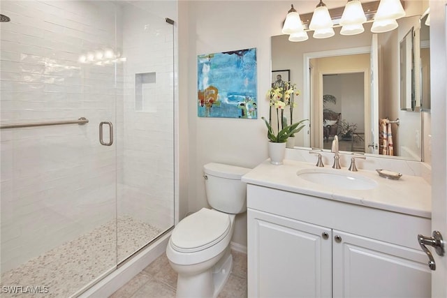 bathroom with vanity, a shower with shower door, tile patterned floors, and toilet