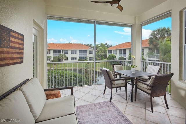 sunroom with a ceiling fan, outdoor dining area, and plenty of natural light