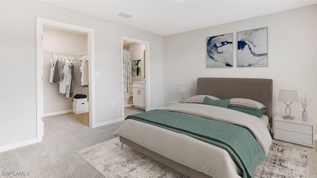 bedroom featuring a closet, visible vents, light colored carpet, a spacious closet, and baseboards