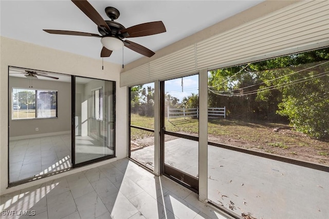 unfurnished sunroom featuring ceiling fan