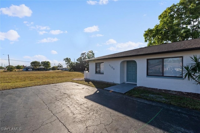 view of front of house with a patio and a front yard