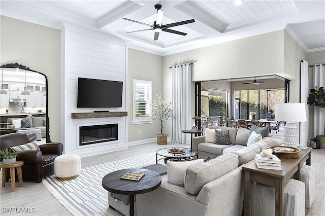 living area with coffered ceiling, ceiling fan, light wood-style flooring, ornamental molding, and a fireplace