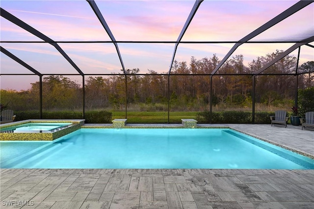 pool at dusk with an in ground hot tub, a patio, and glass enclosure