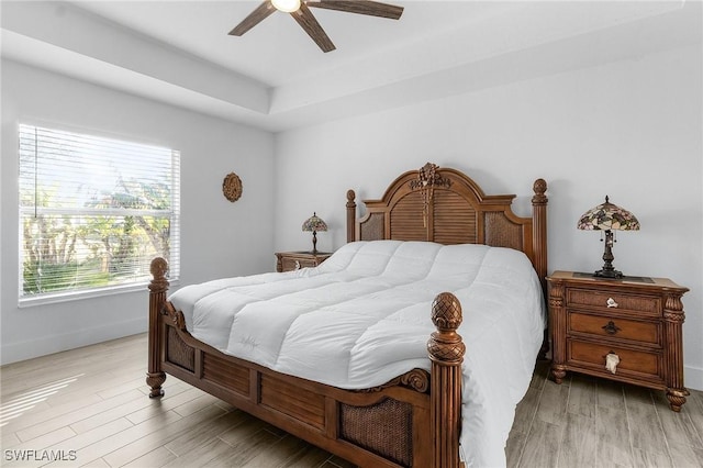 bedroom with ceiling fan, multiple windows, and light hardwood / wood-style flooring