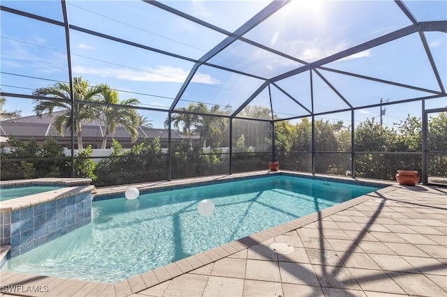 view of pool with an in ground hot tub, glass enclosure, and a patio area