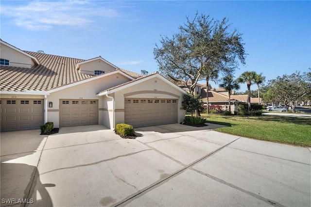 mediterranean / spanish-style house featuring a garage and a front yard