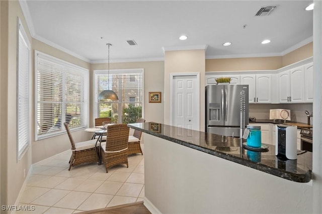 kitchen featuring pendant lighting, dark stone countertops, ornamental molding, white cabinets, and stainless steel fridge with ice dispenser