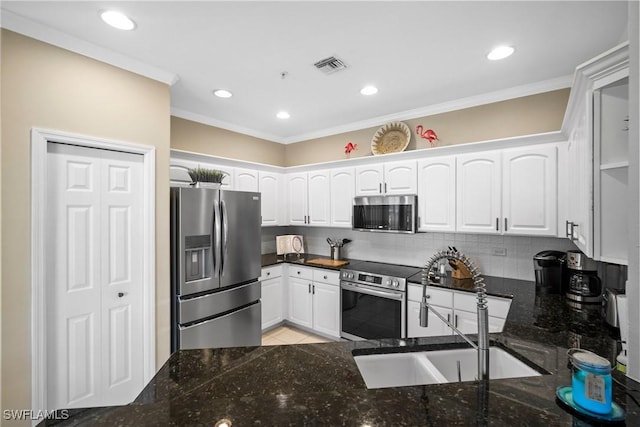 kitchen featuring sink, backsplash, stainless steel appliances, and white cabinets