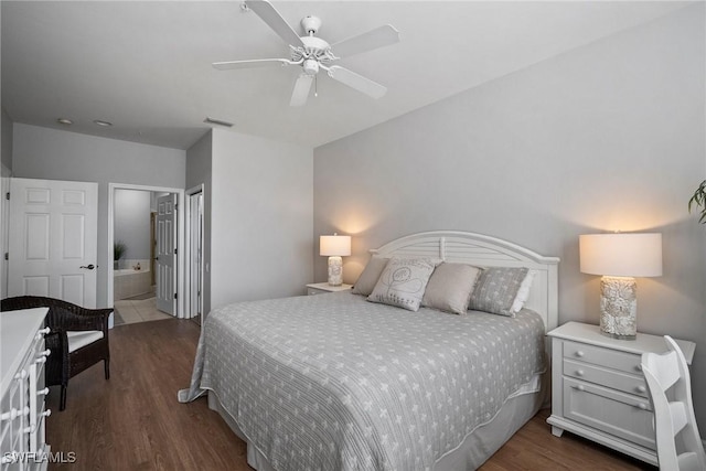 bedroom with ceiling fan, ensuite bath, and dark hardwood / wood-style floors