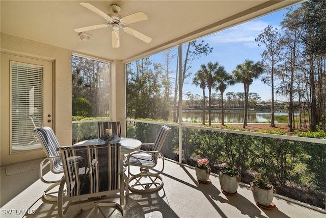 sunroom / solarium featuring a water view and ceiling fan