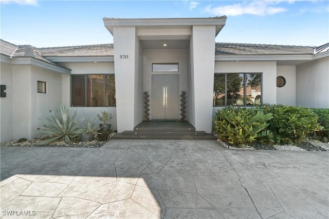 view of exterior entry with a patio area