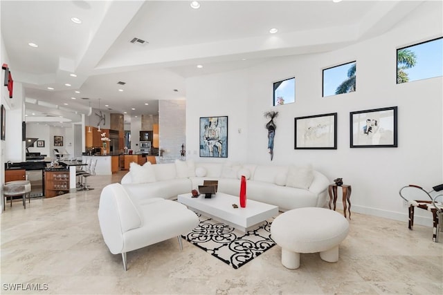 living room featuring wine cooler, beam ceiling, and a wealth of natural light