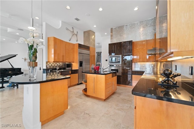 kitchen featuring a kitchen island, pendant lighting, sink, backsplash, and built in appliances