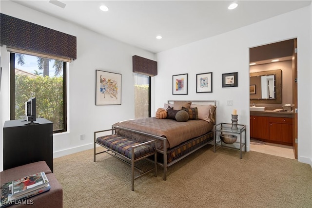 bedroom with light colored carpet and ensuite bathroom