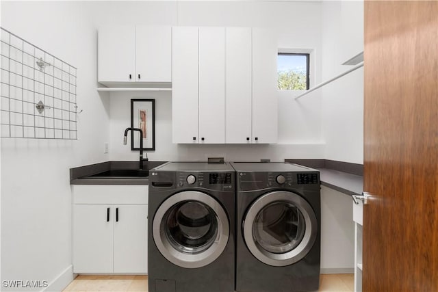 washroom featuring cabinets, sink, and independent washer and dryer