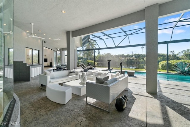 view of patio featuring an outdoor living space, ceiling fan, a water view, and glass enclosure