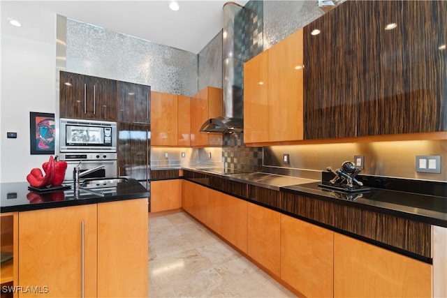 kitchen with appliances with stainless steel finishes, wall chimney range hood, and backsplash