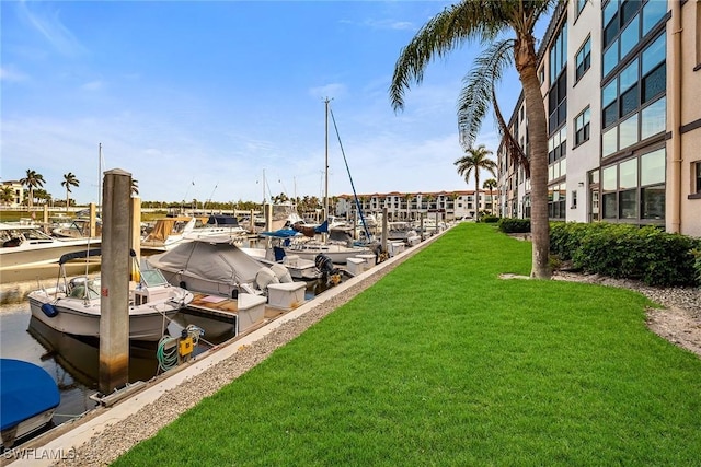 view of dock with a water view and a lawn