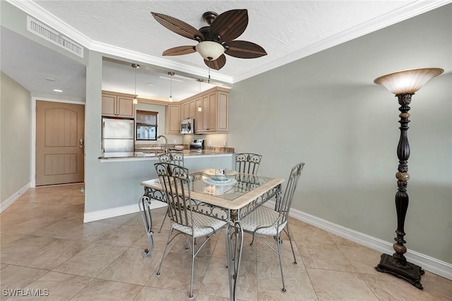 tiled dining room featuring crown molding, sink, and ceiling fan