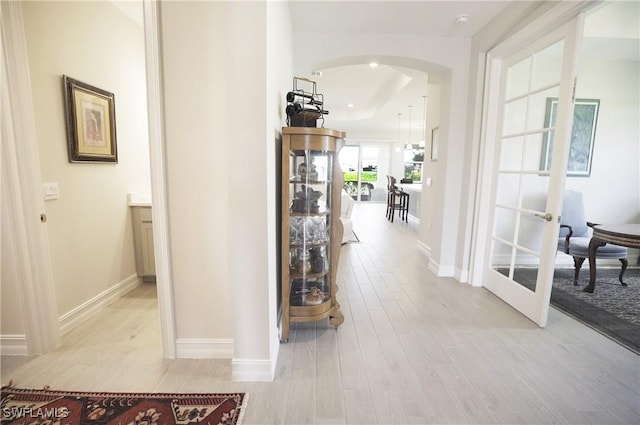 hall with french doors and light wood-type flooring