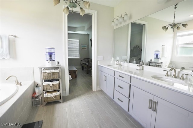 bathroom with vanity and tiled tub