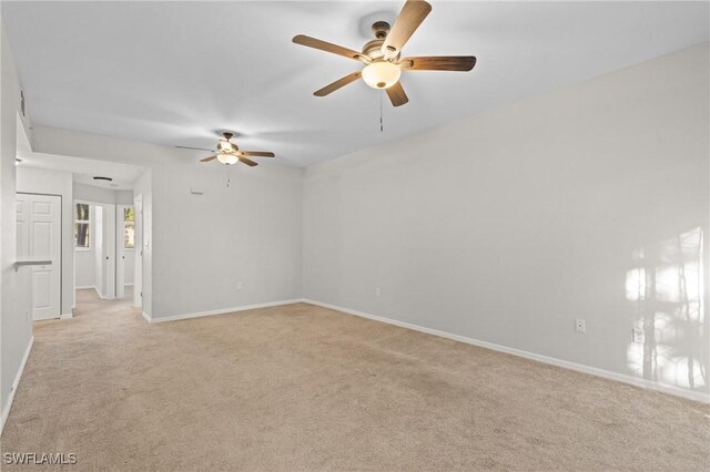 spare room with light colored carpet and ceiling fan