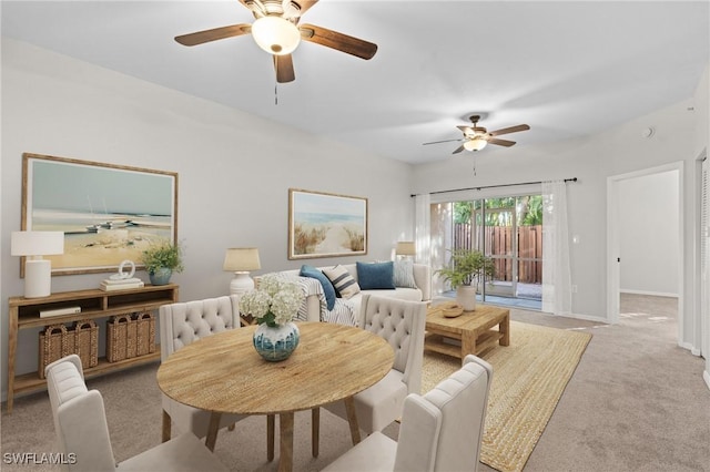 carpeted dining space featuring ceiling fan and baseboards