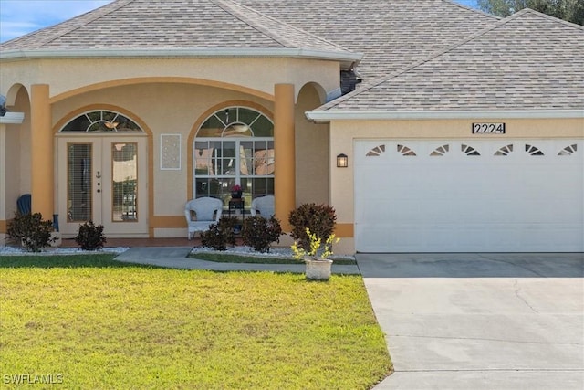 view of front facade with french doors, a garage, and a front yard