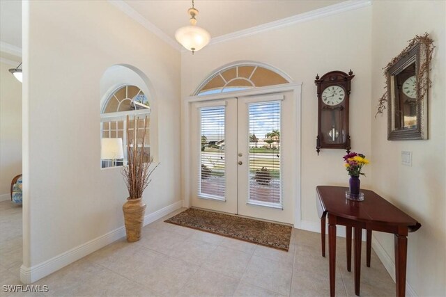 entrance foyer featuring light tile patterned floors, ornamental molding, and french doors