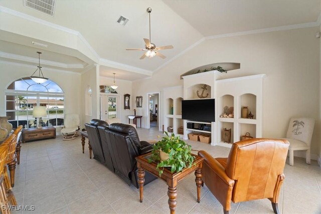 living room with ornamental molding, light tile patterned floors, ceiling fan, and built in shelves