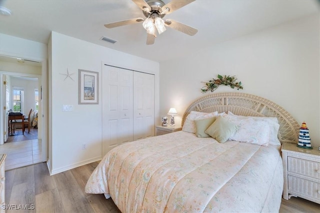 bedroom with ceiling fan, hardwood / wood-style floors, and a closet