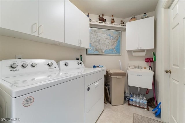 laundry area featuring cabinets, sink, and washing machine and clothes dryer