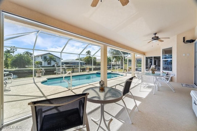 view of pool with ceiling fan, glass enclosure, and a patio area