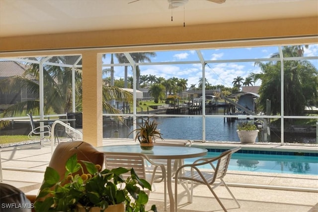 sunroom with a water view and ceiling fan