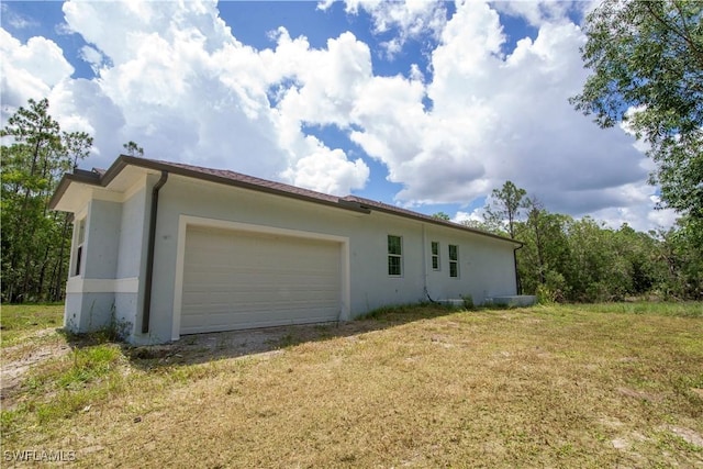 view of property exterior featuring a lawn, an attached garage, and stucco siding