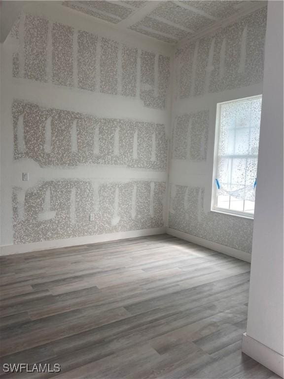 unfurnished room featuring baseboards and wood finished floors