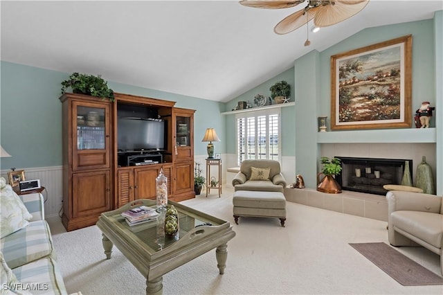 living room featuring ceiling fan, lofted ceiling, light colored carpet, and a fireplace