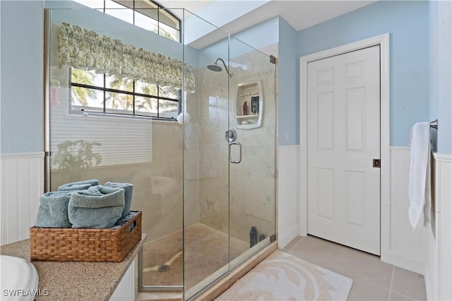 bathroom featuring a wealth of natural light, tile patterned floors, and walk in shower