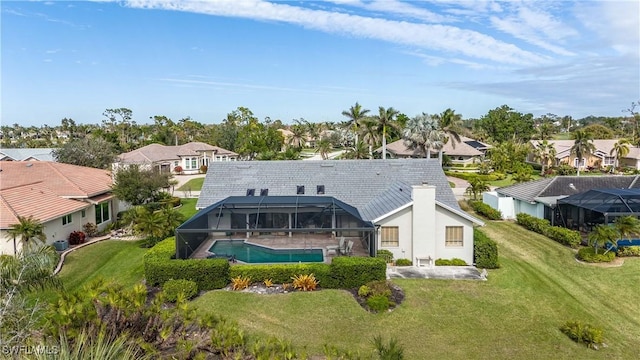 rear view of house with a lanai and a lawn