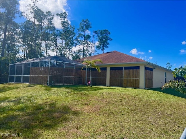 exterior space with a lanai and a lawn