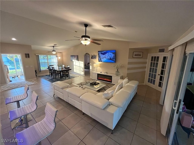 tiled living room with visible vents, lofted ceiling, a ceiling fan, and french doors