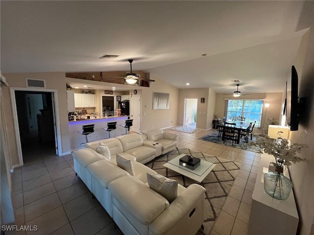 tiled living area with vaulted ceiling, visible vents, and ceiling fan