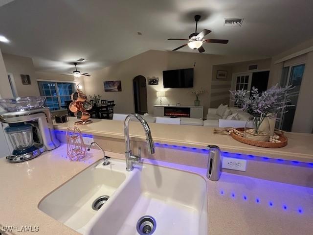 kitchen featuring ceiling fan and vaulted ceiling