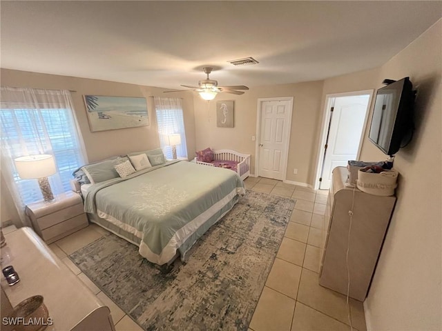 tiled bedroom featuring multiple windows and ceiling fan